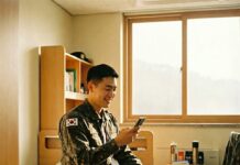 “병장 월급 200만 원 시대” 2026년 새해, 국방의 의무가 ‘기회’가 되는 이유 스마트폰으로 늘어난 월급과 적금 잔액을 확인하며 밝게 웃고 있는 2026년 한국인 병장의 모습